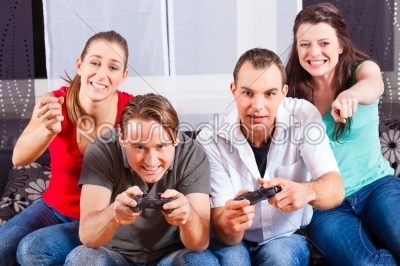Friends sitting in front of game console box