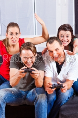 Friends sitting in front of game console box