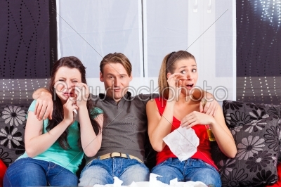 Friends watching a sad movie in TV