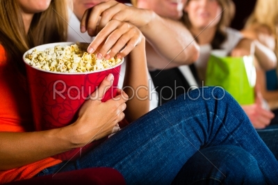 Girl eating popcorn in cinema or movie theater