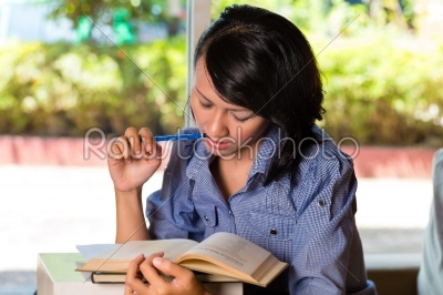 Girl with pile of books learning