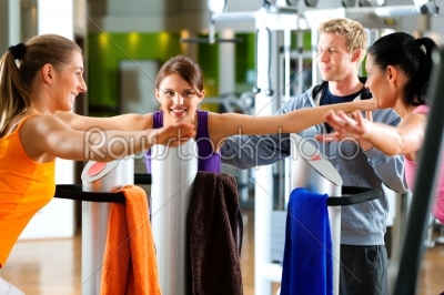 Gym - women and trainer front of exercising machine