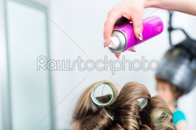 Hairdresser - hair stylist curling hairs