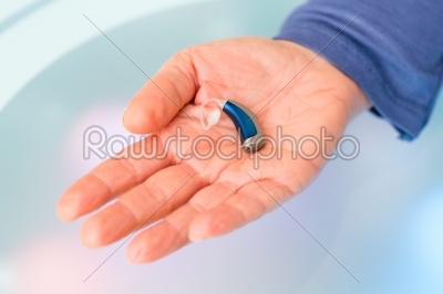 Hand holding hearing aid