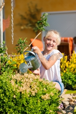 Happy child watering flowers