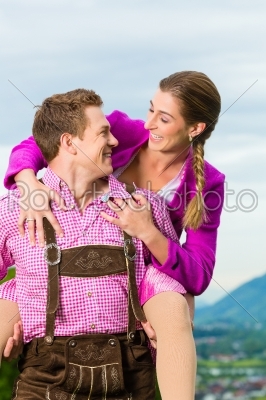 Happy couple in Alpine meadow in Tracht