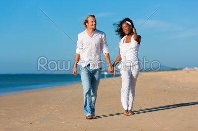 Happy couple walking and running on beach