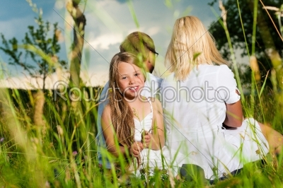Happy family sitting in meadow