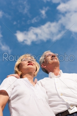 Happy mature couple looking to the blue sky