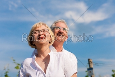 Happy senior couple looking to the blue sky