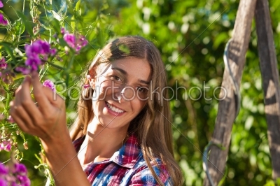 Happy woman in garden with flowers