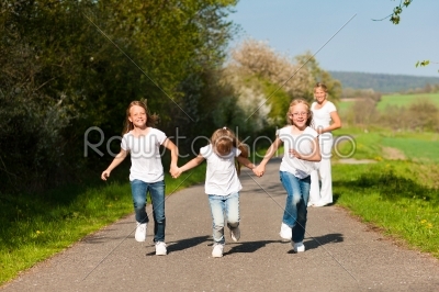kids running down a path, pregnant mother standing 