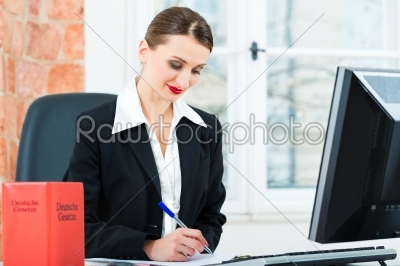 Lawyer in office making notes in a file