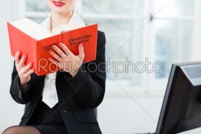 Lawyer in office reading law book