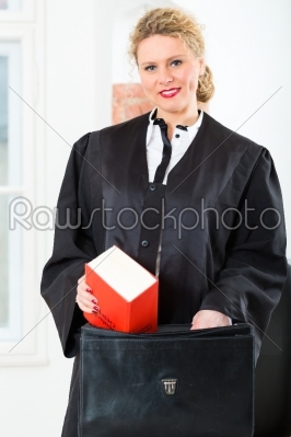 Lawyer in office with law book and case