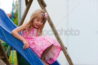 Little girl on slide in summer