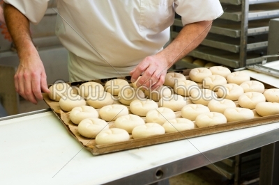 Male baker baking bread rolls