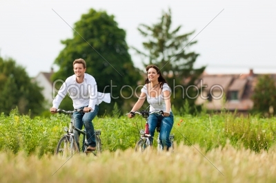 Man and woman cycling in summer