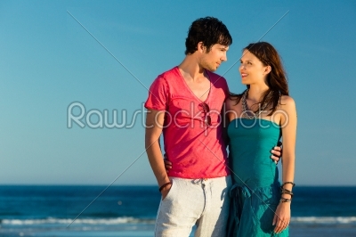 Man and woman enjoying sunset on beach