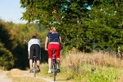 Man and woman exercising with bicycle