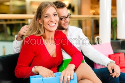 Man and woman in shopping mall with bags