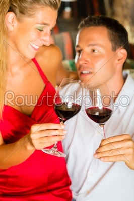 Man and woman tasking wine in cellar