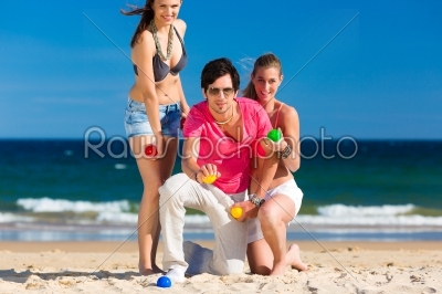 Man and women playing boule on beach