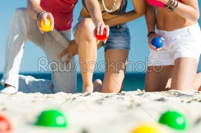 Man and women playing boule on beach