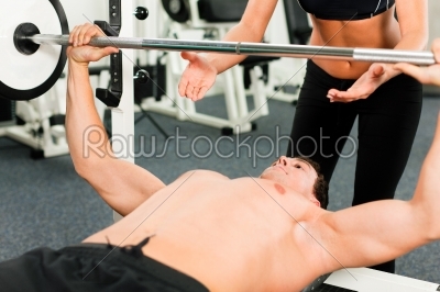man in gym exercising with barbell