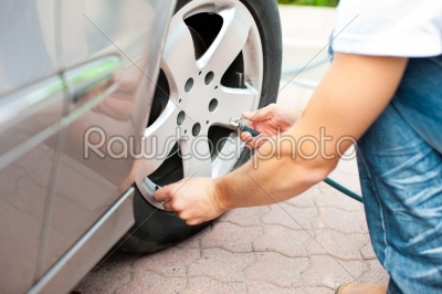 Man is controlling the tire pressure of his car