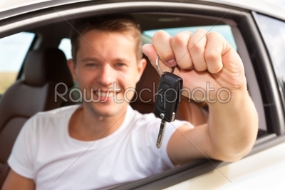 Man is holding his car key sitting inside