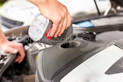 Man is refilling oil in his car