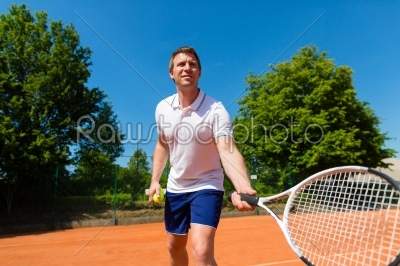 Man playing tennis on court outdoors 