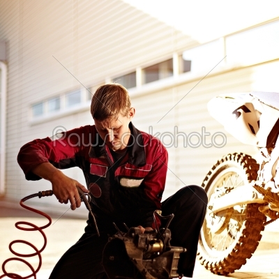 man repairing a sports bike