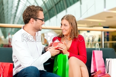 Man with gift for woman in mall