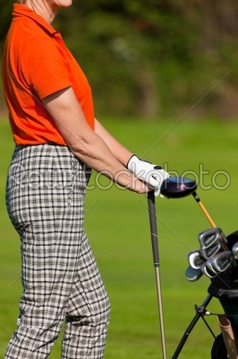 Mature Woman with golf bag playing golf