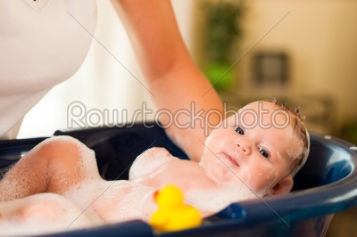 Mother is bathing her baby