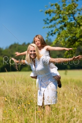Mother with daughter in meadow