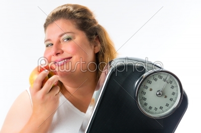 Obese woman with scale under arm and apple