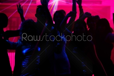 People dancing in club with laser