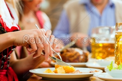 People eating roast pork in Bavarian restaurant