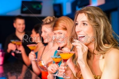 People in club or bar drinking cocktails