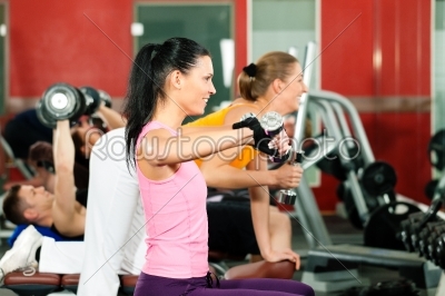 People in gym exercising with weights