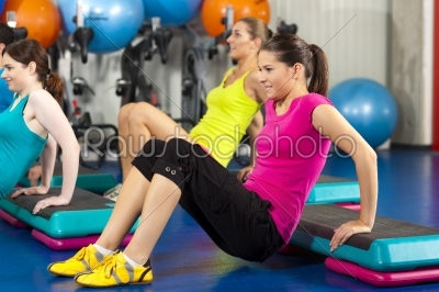 People in gym on step board