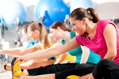 People in gym warming up stretching