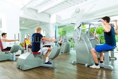 People in sport gym on machines