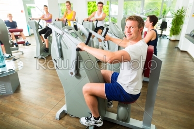 People in sport gym on machines