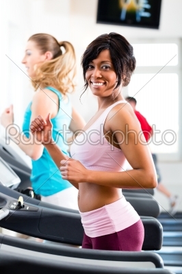 People in sport gym on treadmill running
