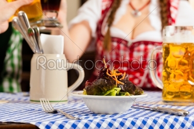 People in traditional Bavarian Tracht eating in restaurant or pub