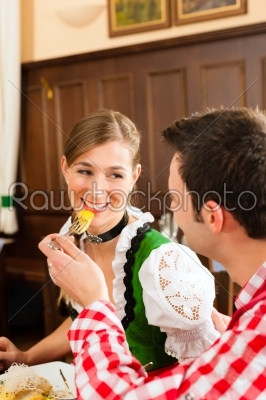 People in traditional Bavarian Tracht eating in restaurant or pub